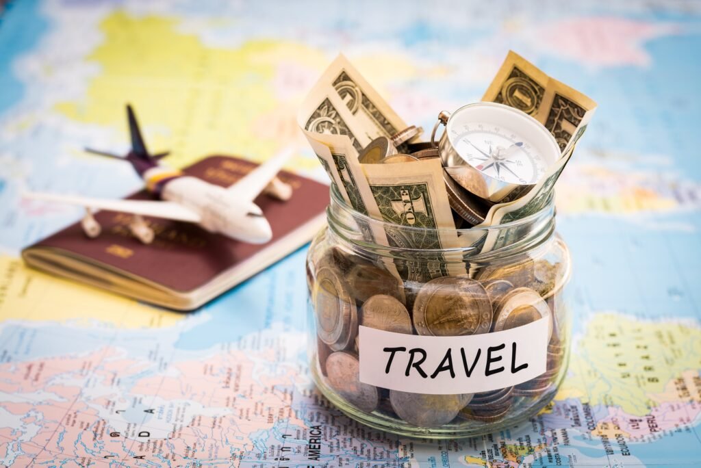 jar filled with money, map, book, aeroplane concept showing showing to save money for hotel bookings 