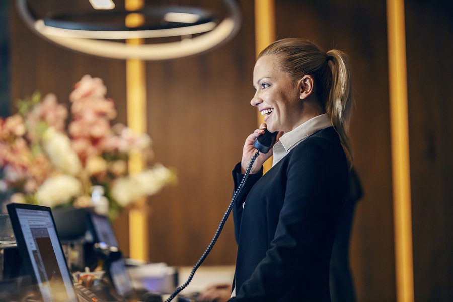 a lady in a hotel on a phone call showing Best Practices in Hospitality